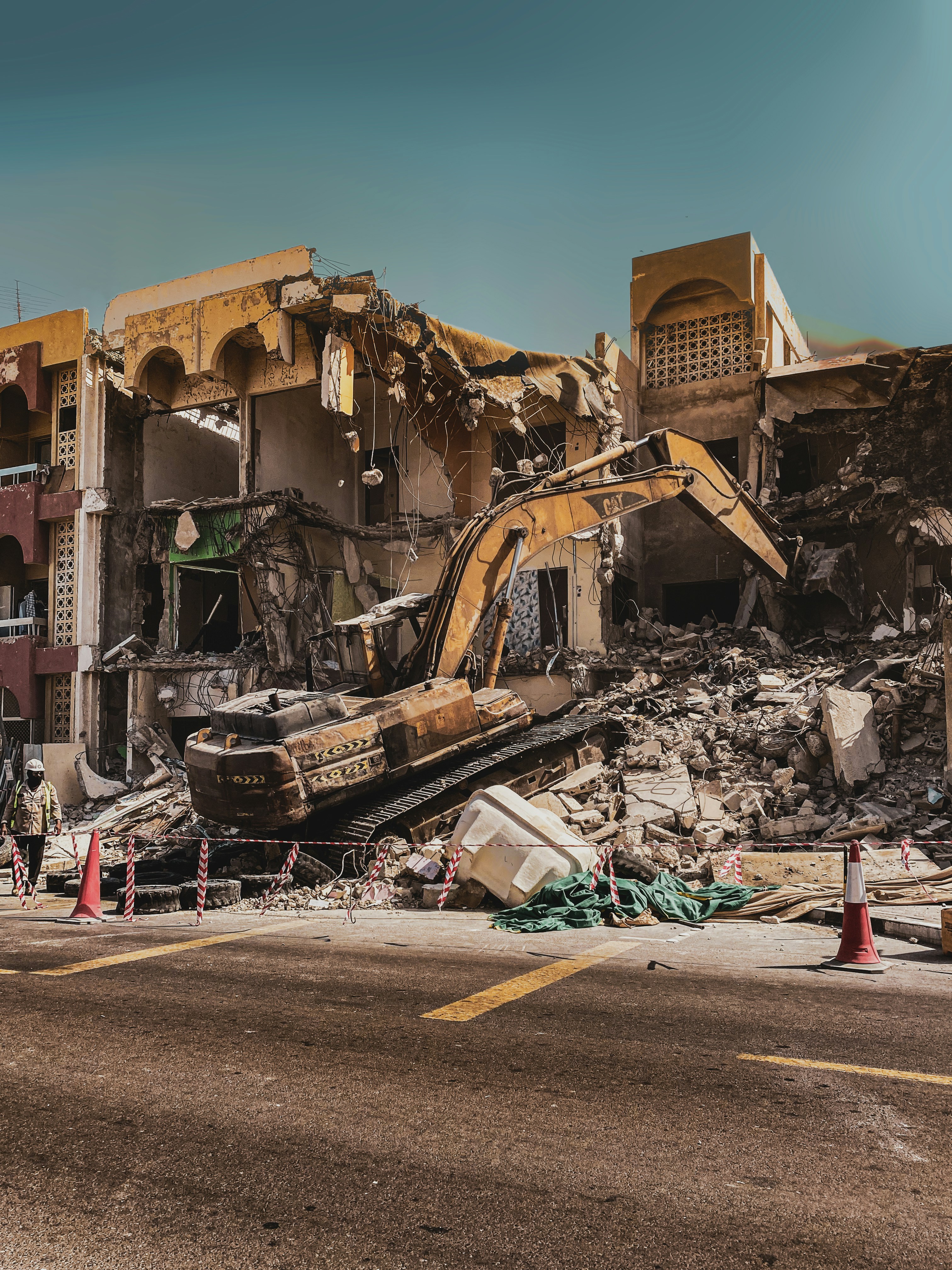 a demolished building with a bulldozer in the foreground