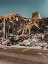 a demolished building with a bulldozer in the foreground