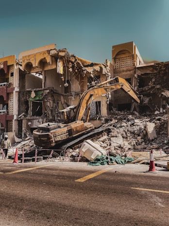 a demolished building with a bulldozer in the foreground