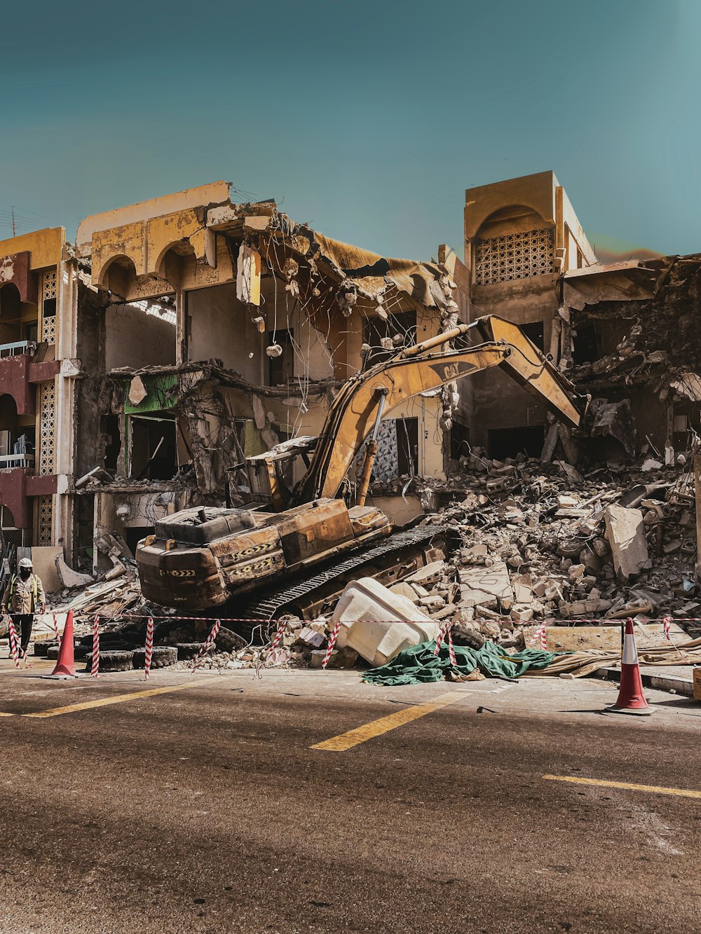 a demolished building with a bulldozer in the foreground