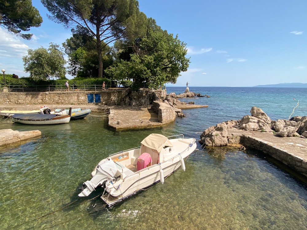 a small boat in the water next to some rocks