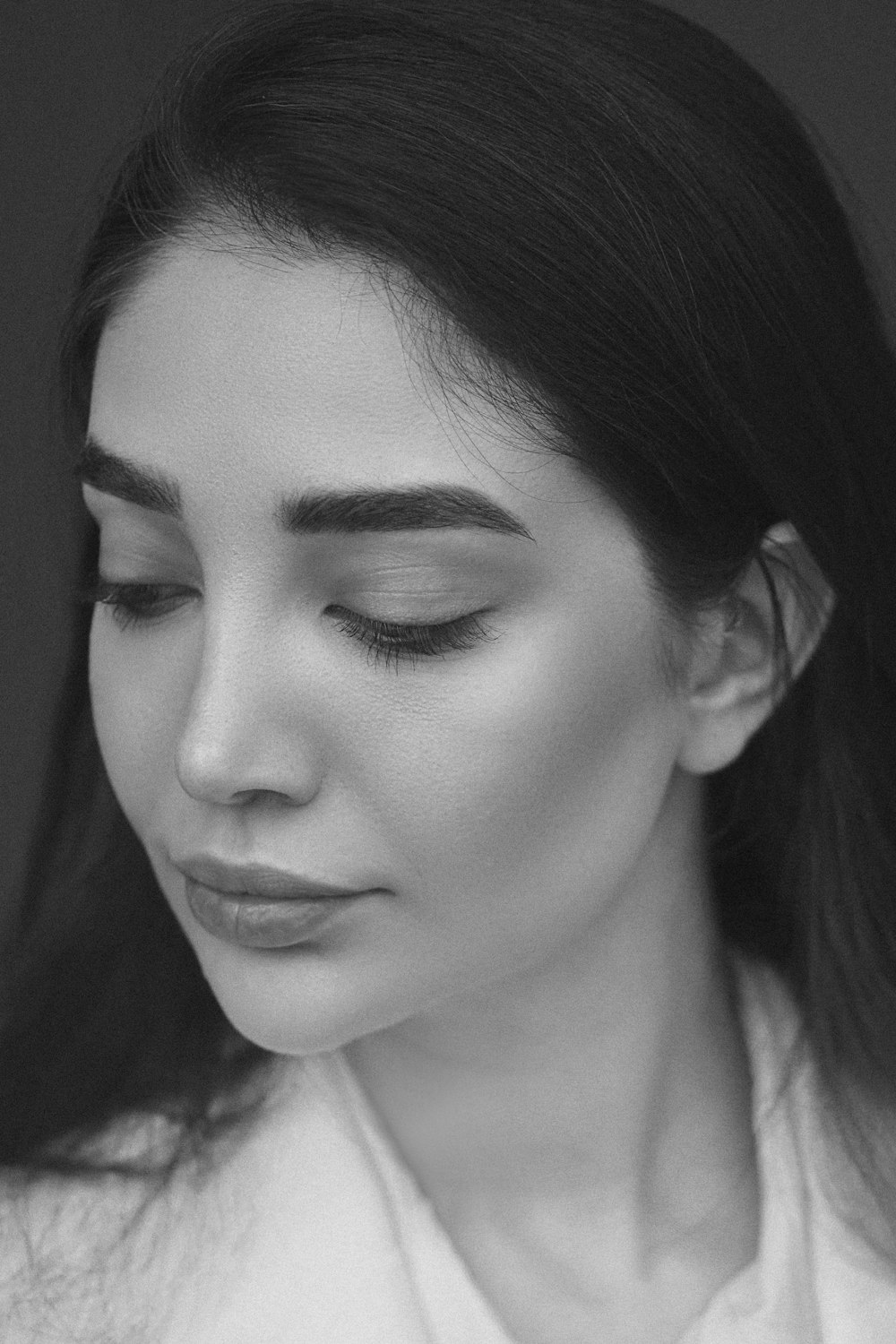 a black and white photo of a woman with her eyes closed