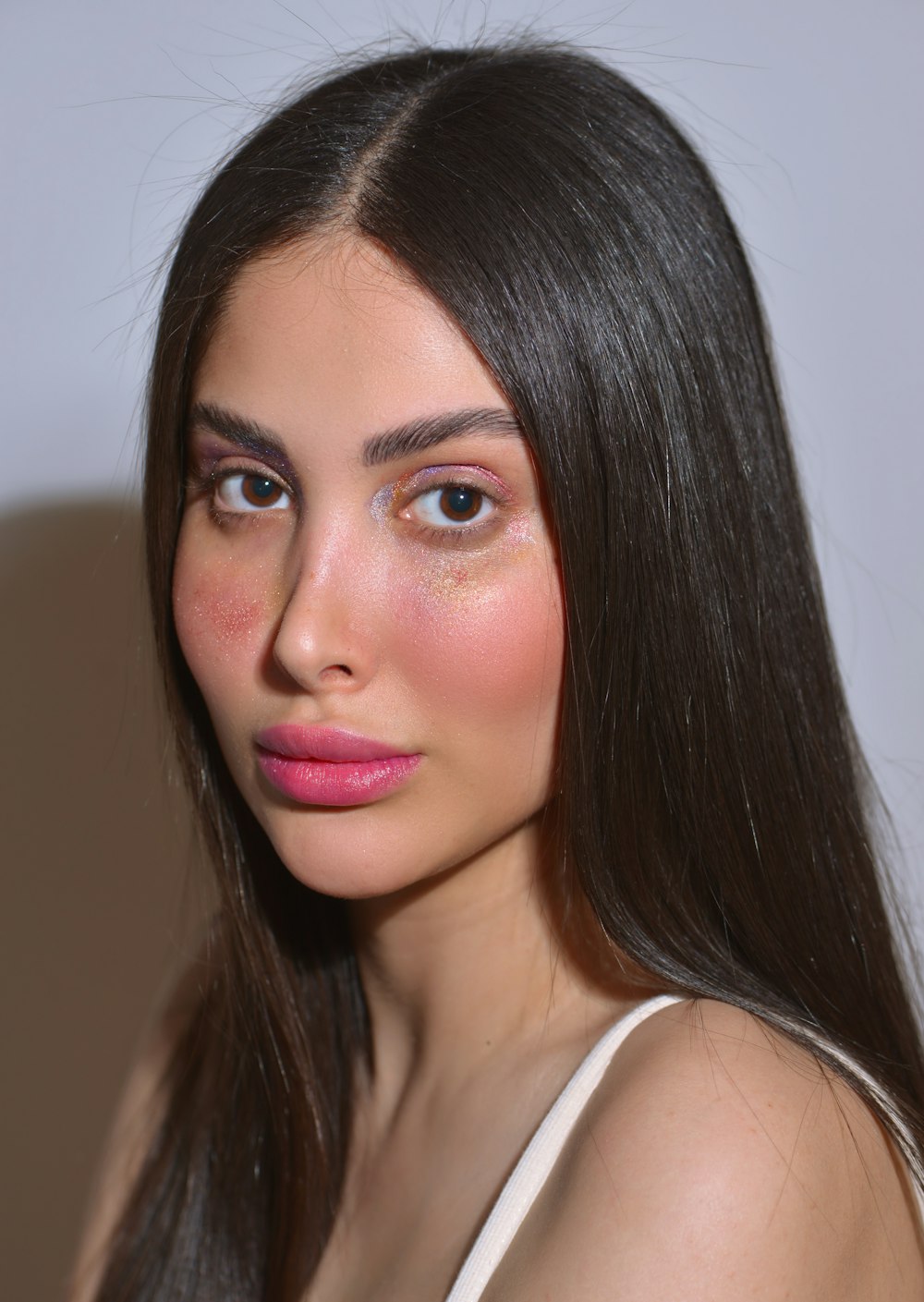 a woman with long brown hair and pink lipstick