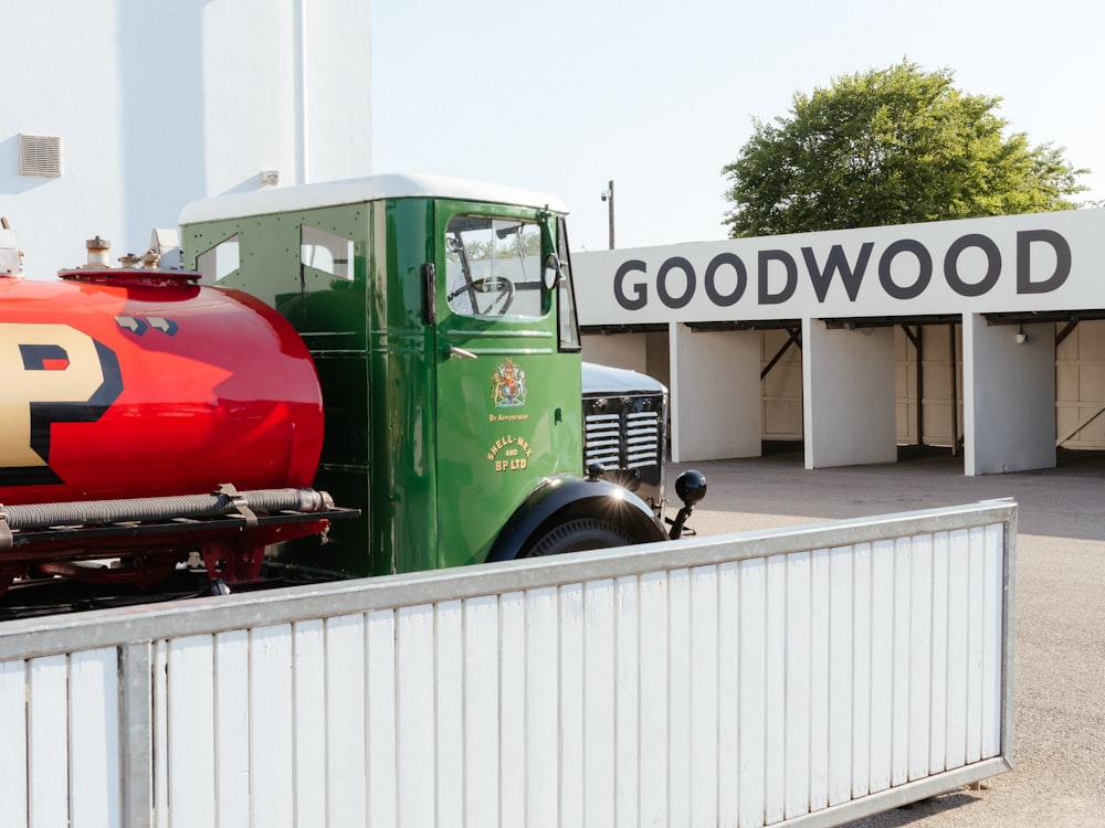 a green and red truck parked in front of a building