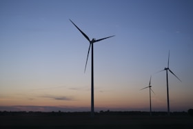 a group of windmills are silhouetted against a blue sky