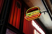 a neon sign hanging from the side of a building