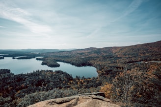 A panoramic view of a peaceful lake surrounded by autumn-colored trees in the 65.