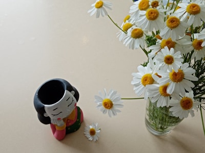 A charming ceramic figurine placed next to a small potted plant.