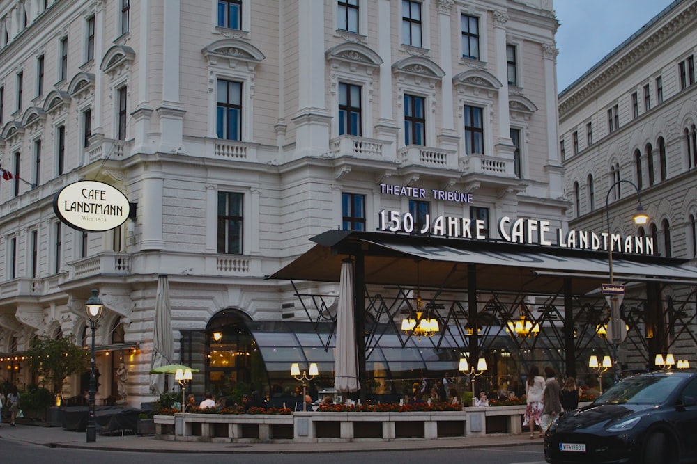 a large white building with a black car parked in front of it