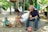a man and a woman sitting on a rock with a dog