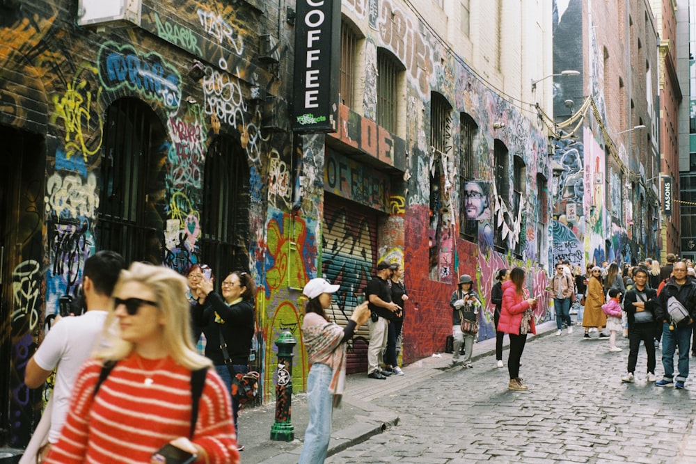 a group of people walking down a street next to tall buildings