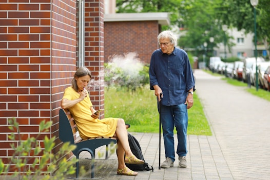 a woman sitting on a bench next to a man