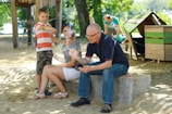Young families enjoying a sunny courtyard with playground and seating.