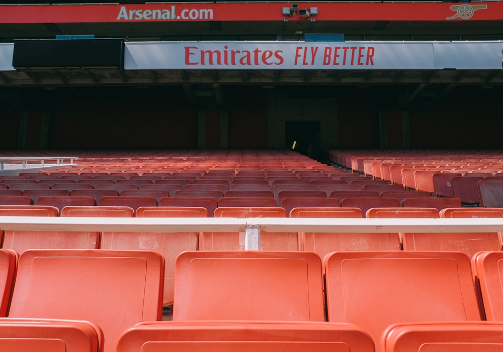 an empty stadium with red seats and a sign