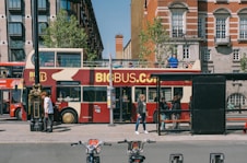 a red double decker bus driving down a street