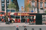 a red double decker bus driving down a street
