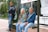 a man and woman sitting on a bench in front of a bus stop