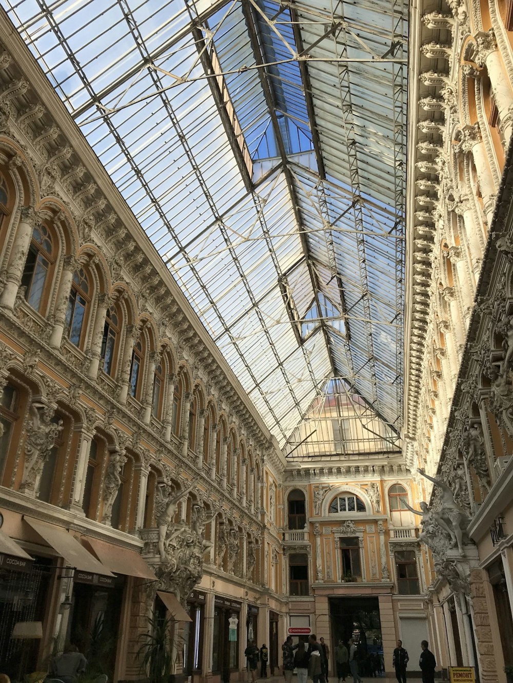 a large building with a glass ceiling and people walking around