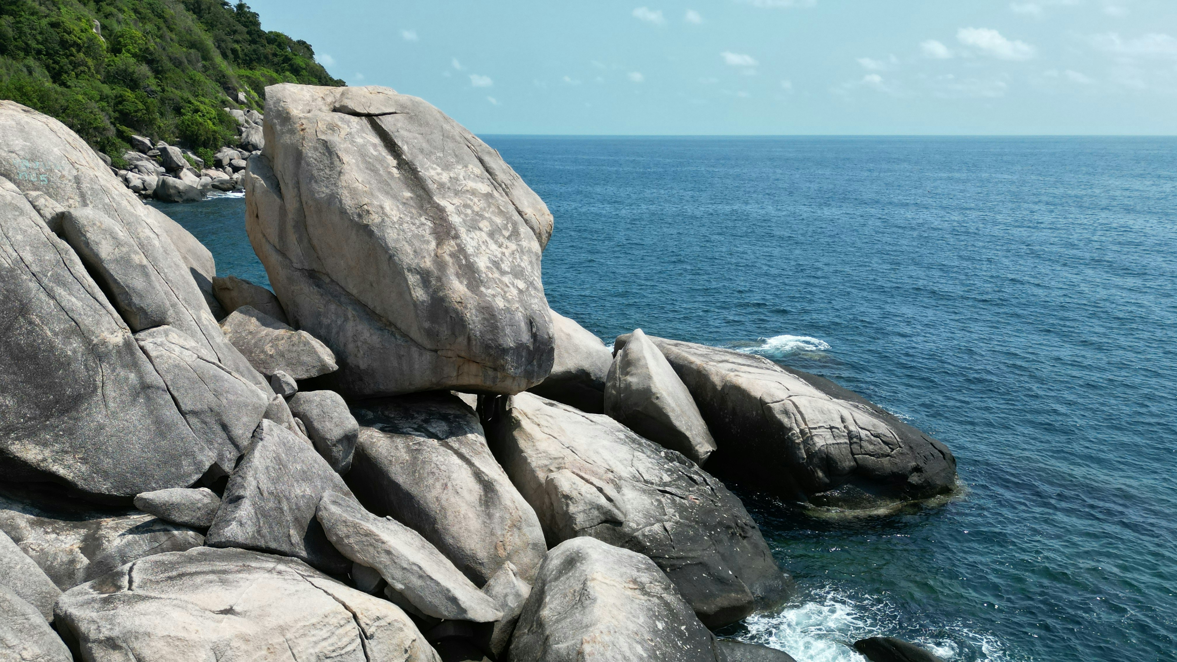 a large rock formation in the middle of a body of water - Koh Tao