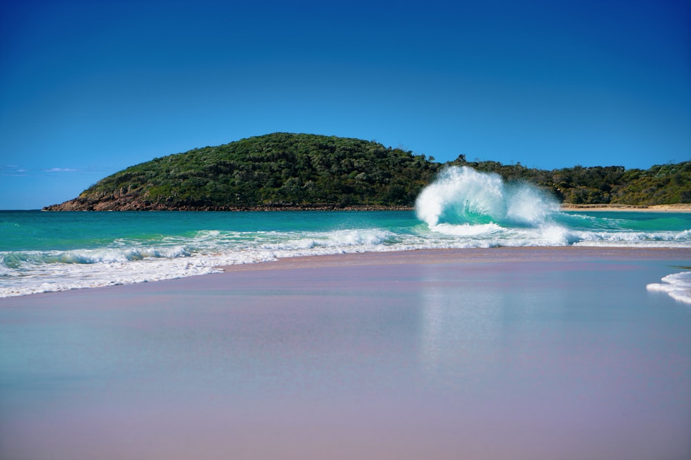 a wave crashes into the shore of a beach