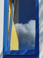Close-up of freshly painted white window trims contrasting with a soft blue house exterior.