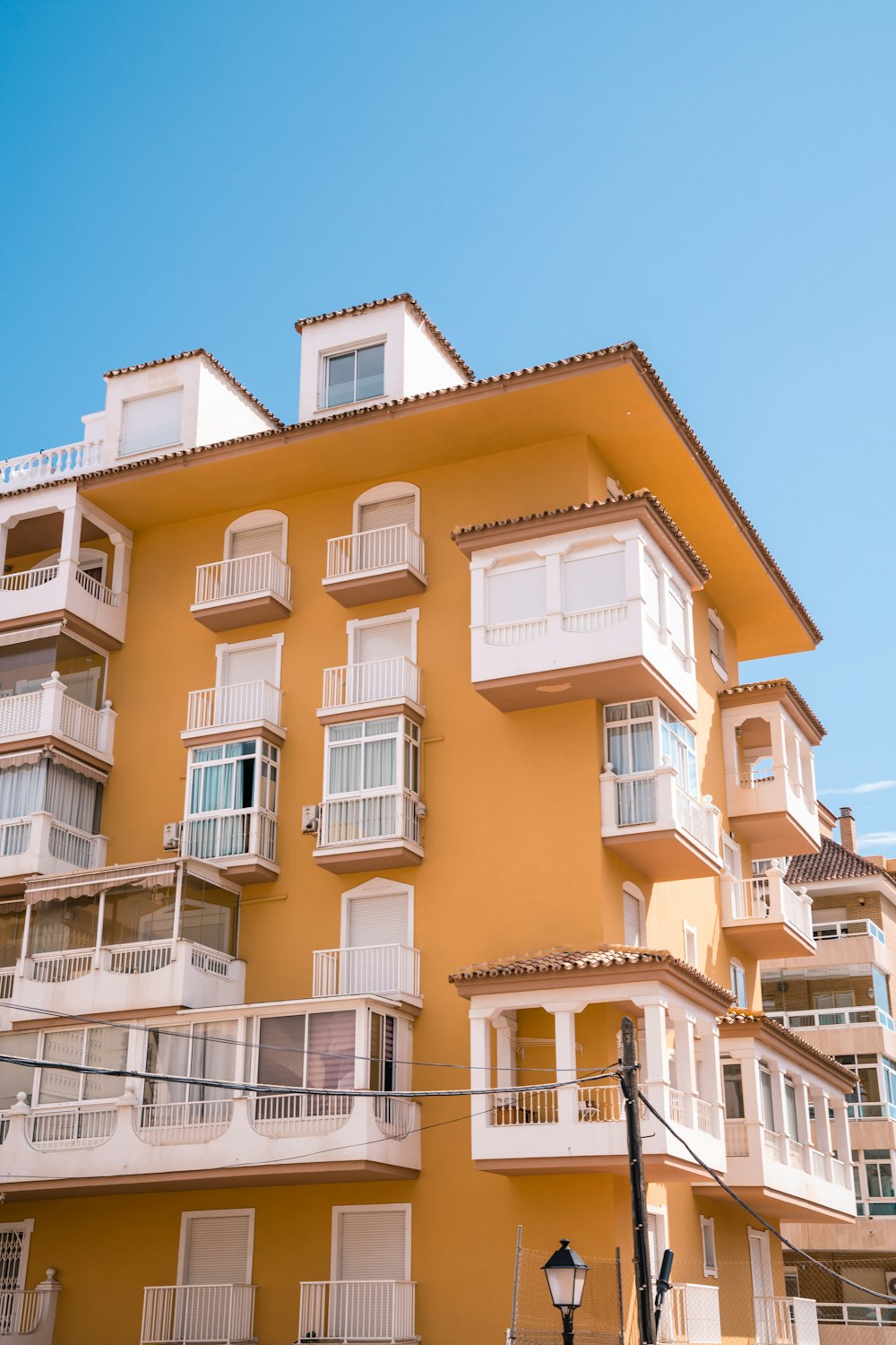 a tall yellow building with balconies and balconies