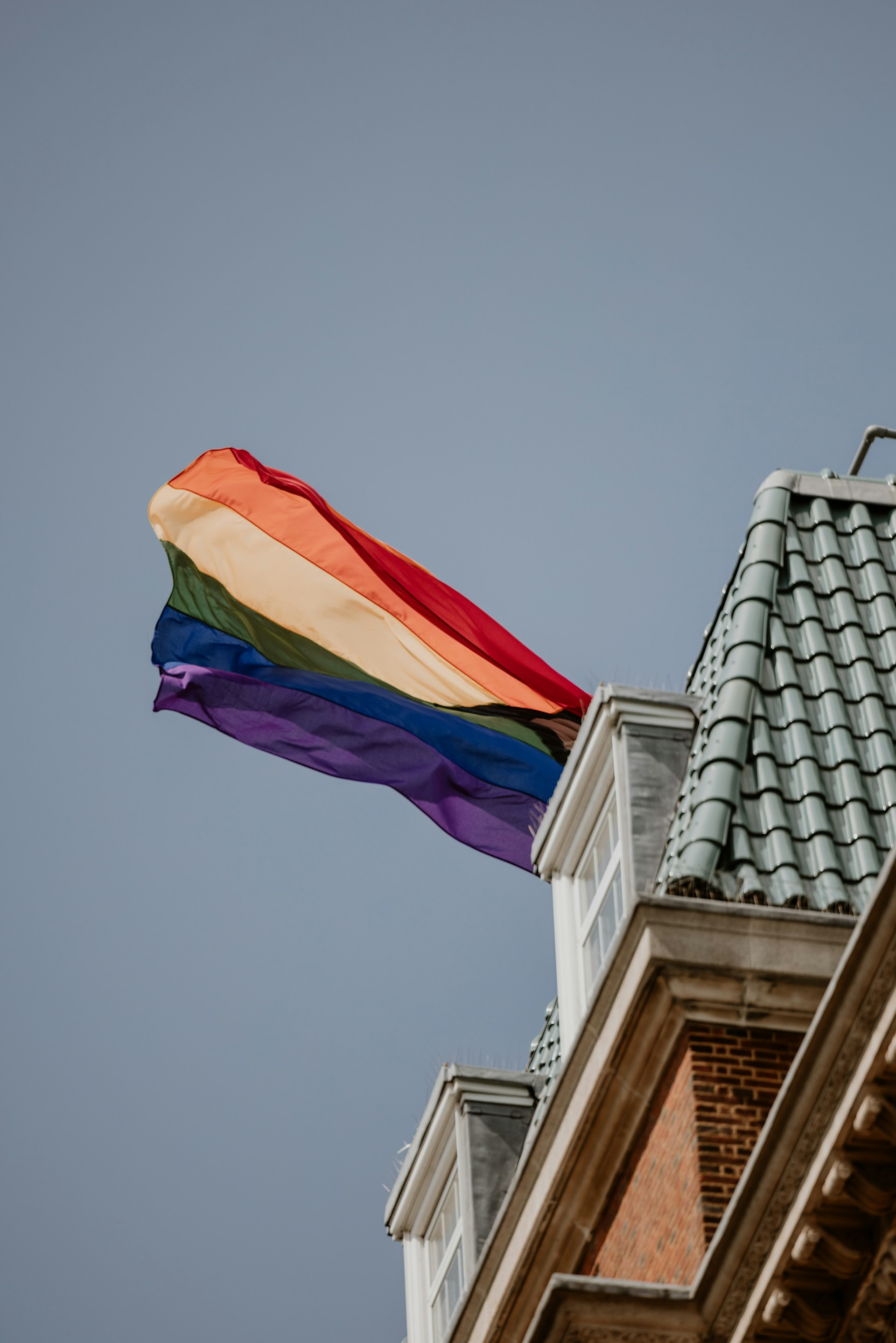 a rainbow flag is flying on top of a building