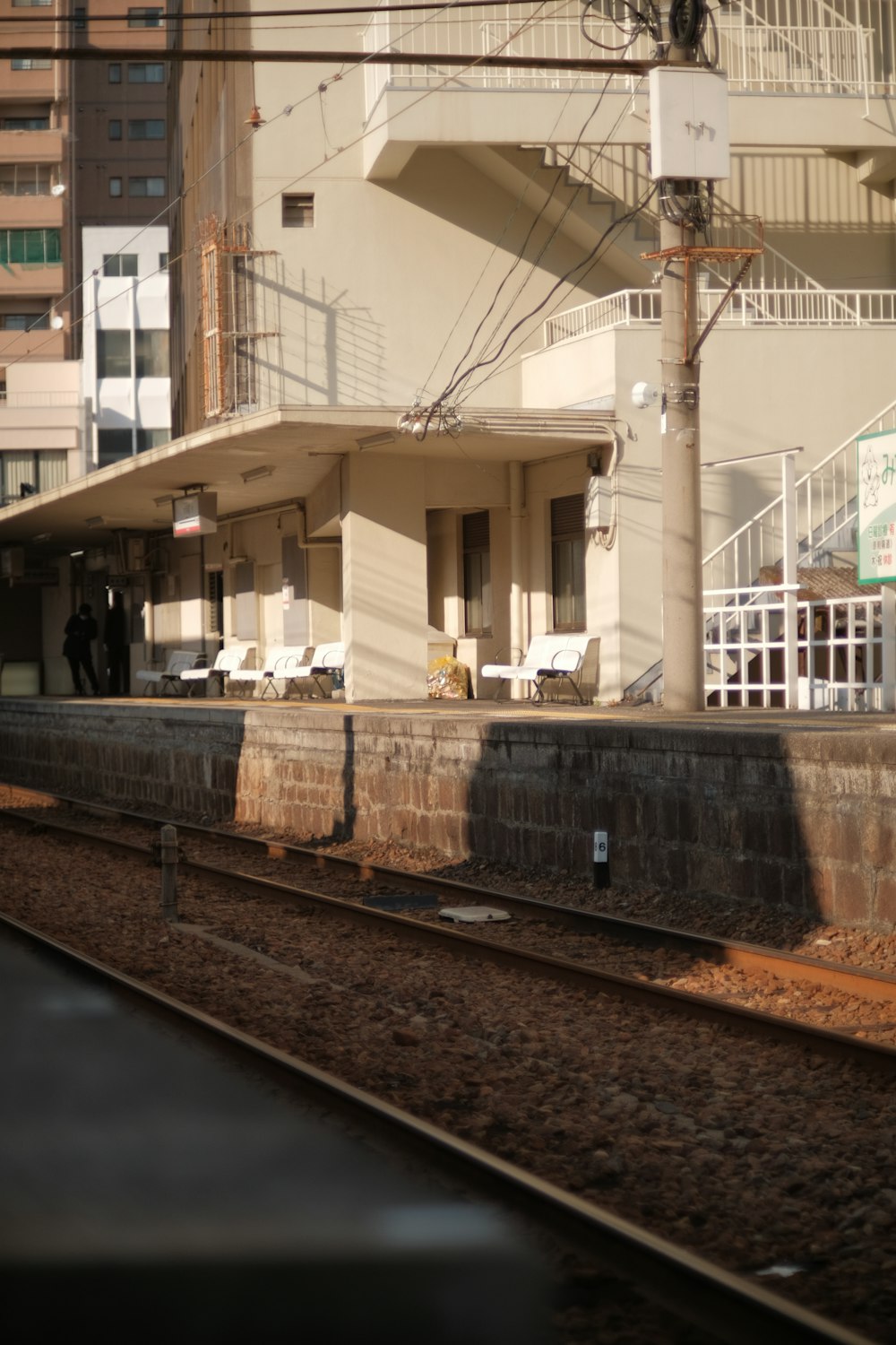 a train traveling past a tall building next to a train track