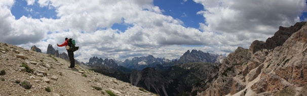 Hikers trekking along a rugged mountain path with backpacks and walking sticks.