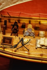 A detailed ship blueprint spread out on a wooden table with nautical instruments nearby.