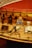 A detailed model of a wooden ship's deck, featuring coiled ropes, wooden barrels, and a well-crafted anchor. There are also bundles of sacks and various nautical elements placed on the realistic-looking planks.