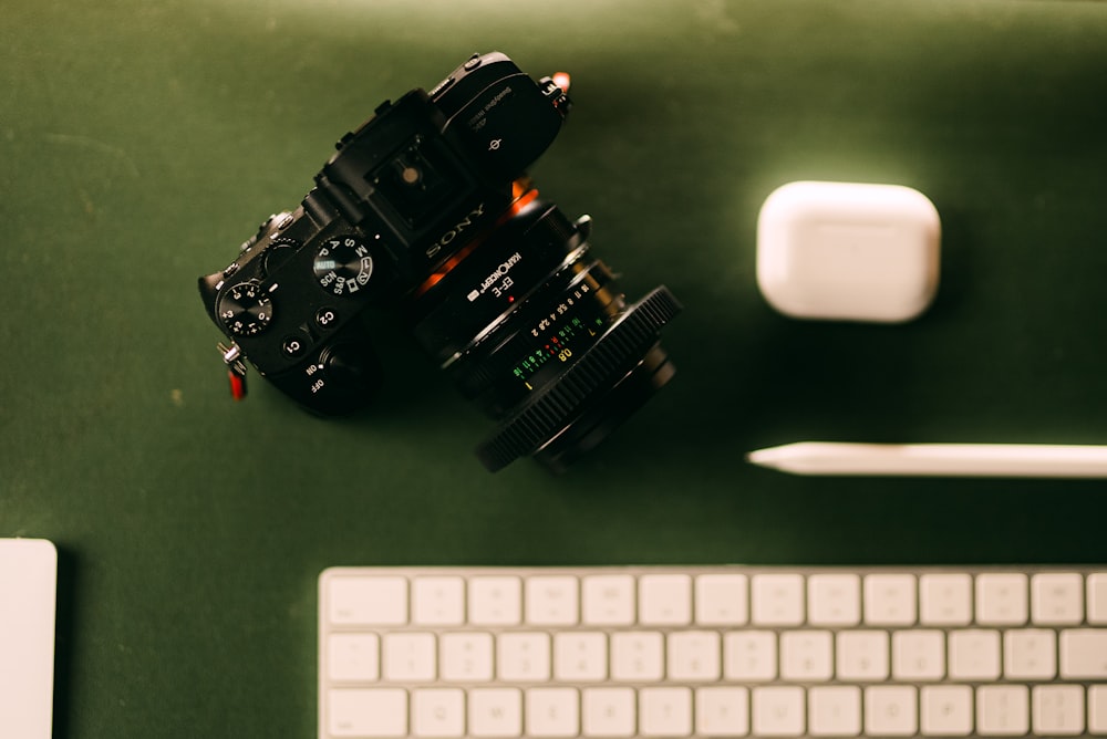 a camera sitting on top of a desk next to a keyboard