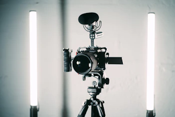 A sleek modern studio setup with professional cameras and lighting capturing a business video shoot.