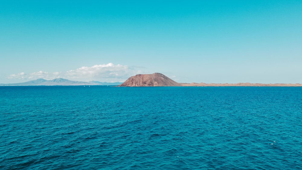 a large body of water with a mountain in the distance