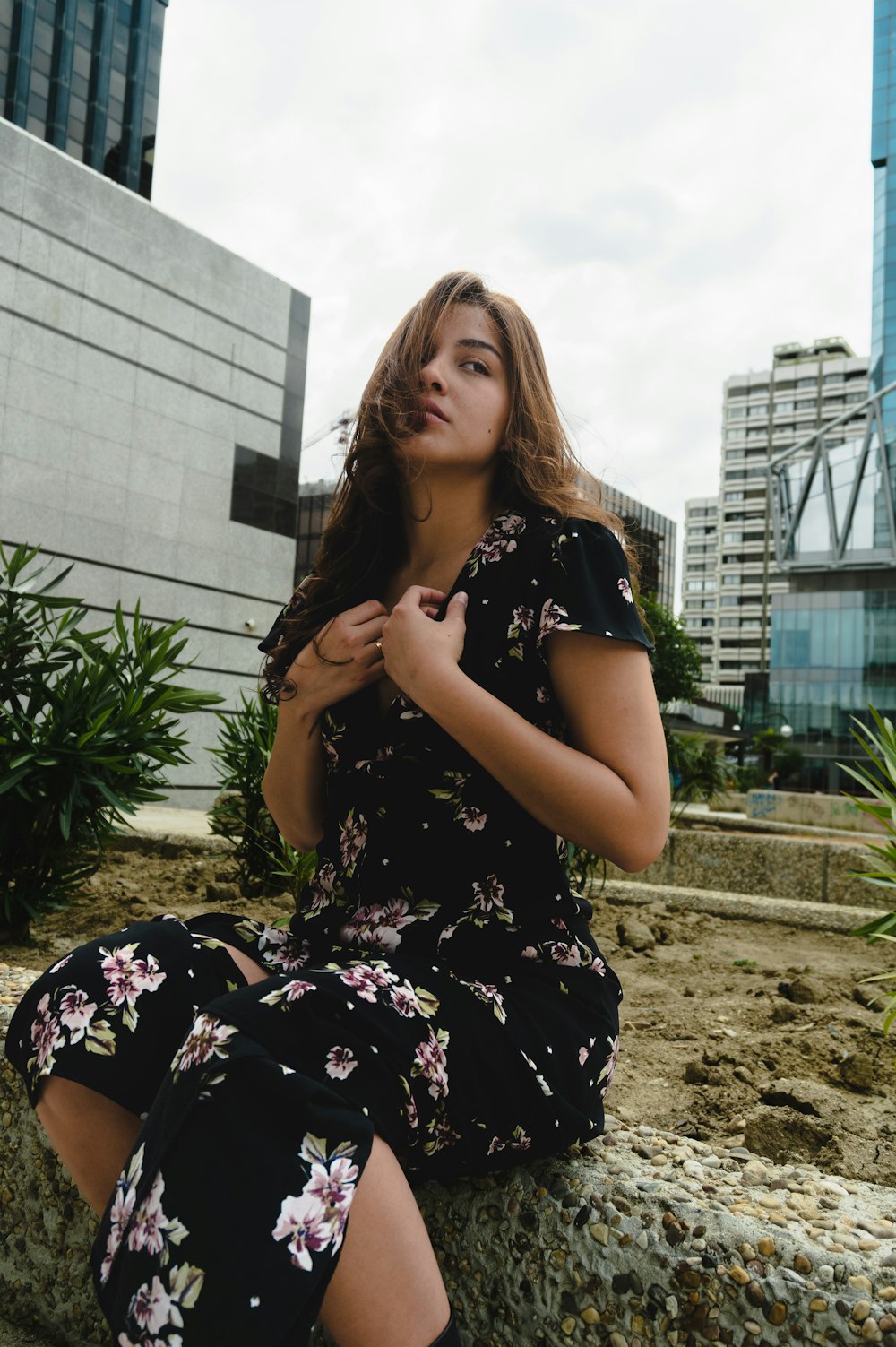 a woman sitting on a rock in a dress