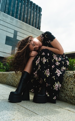 a woman sitting on the ground with her head on her knees