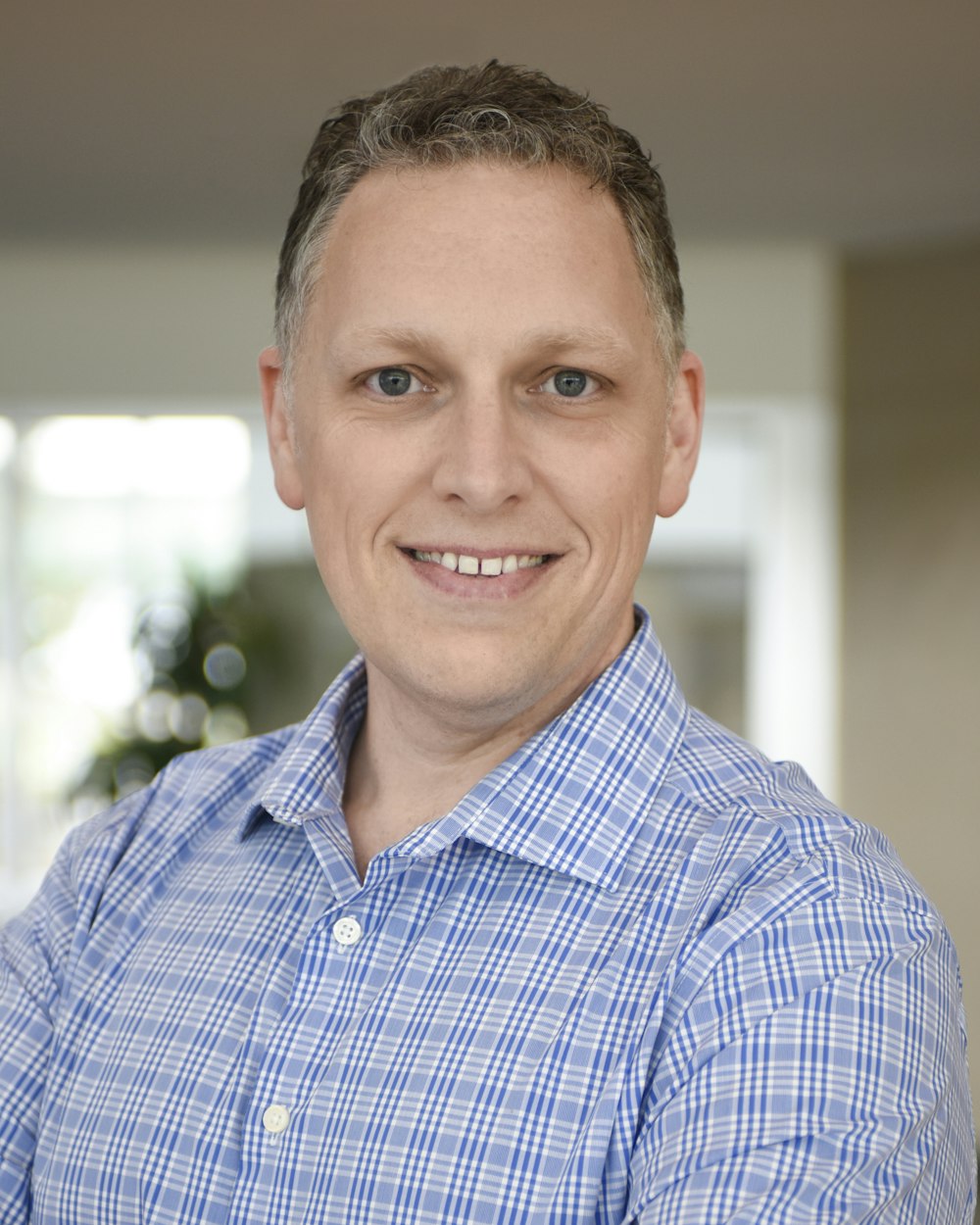 a man in a blue shirt smiling at the camera