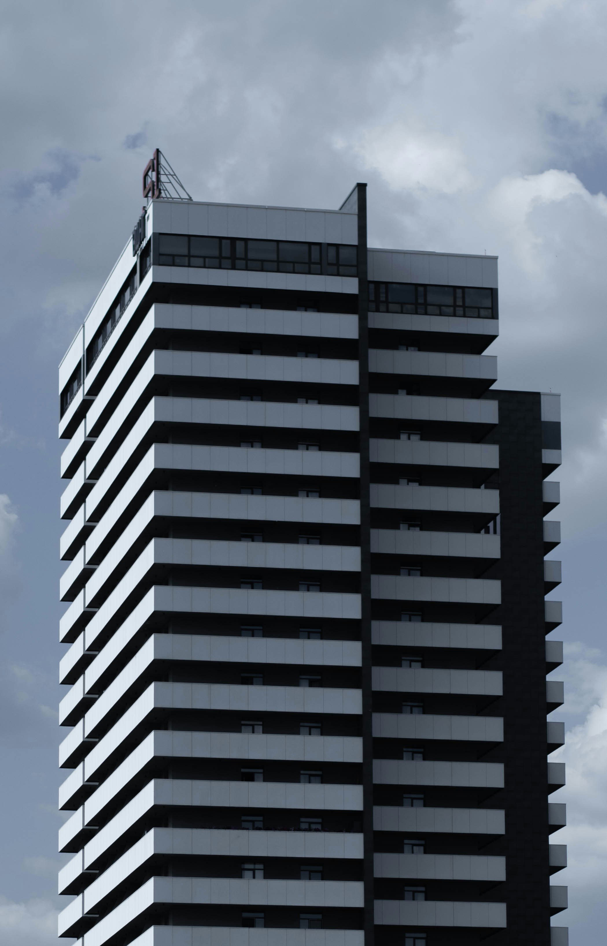 a tall black and white building on a cloudy day