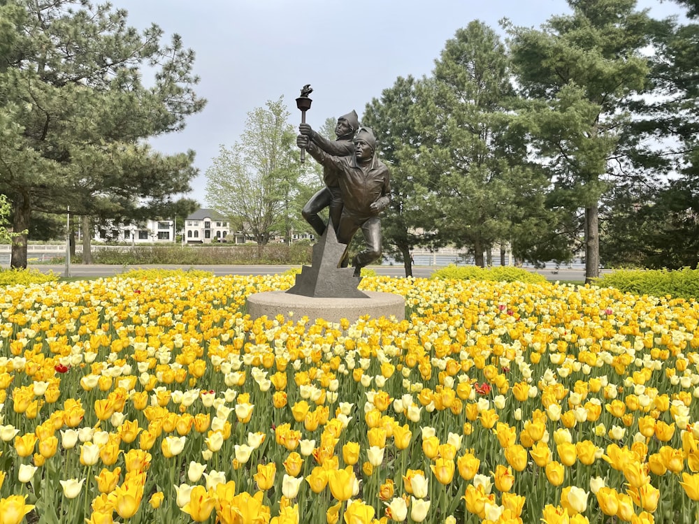 uma estátua em um campo de flores amarelas