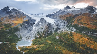 a snow covered mountain range with a lake below