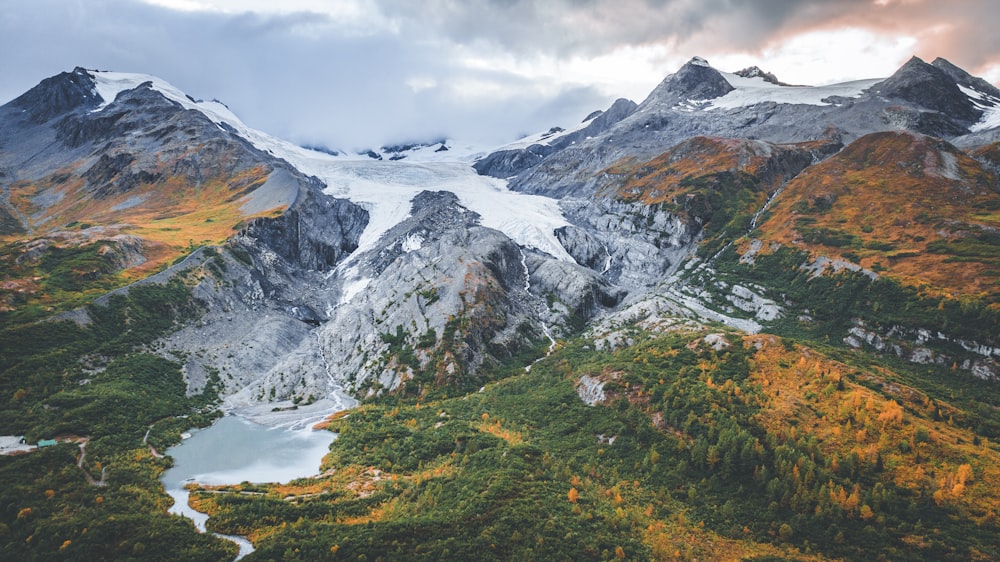 uma cordilheira coberta de neve com um lago abaixo