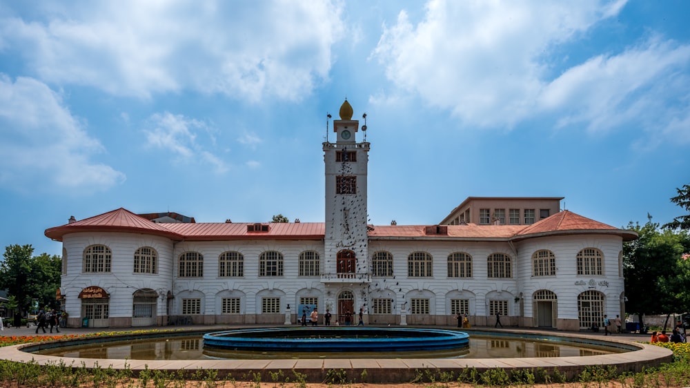 a large white building with a fountain in front of it