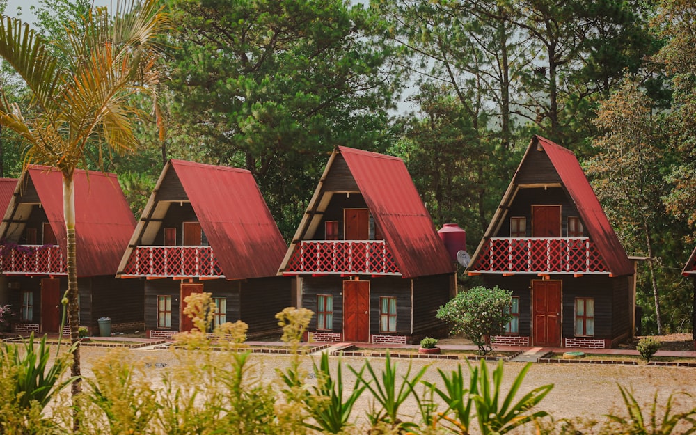 a row of wooden cabins with red roof tops