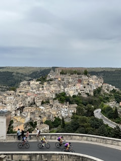 Cyclists navigating through charming streets of a Catalan village.