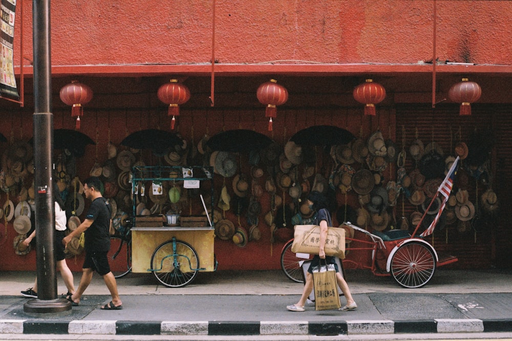 a group of people walking down a street past a store