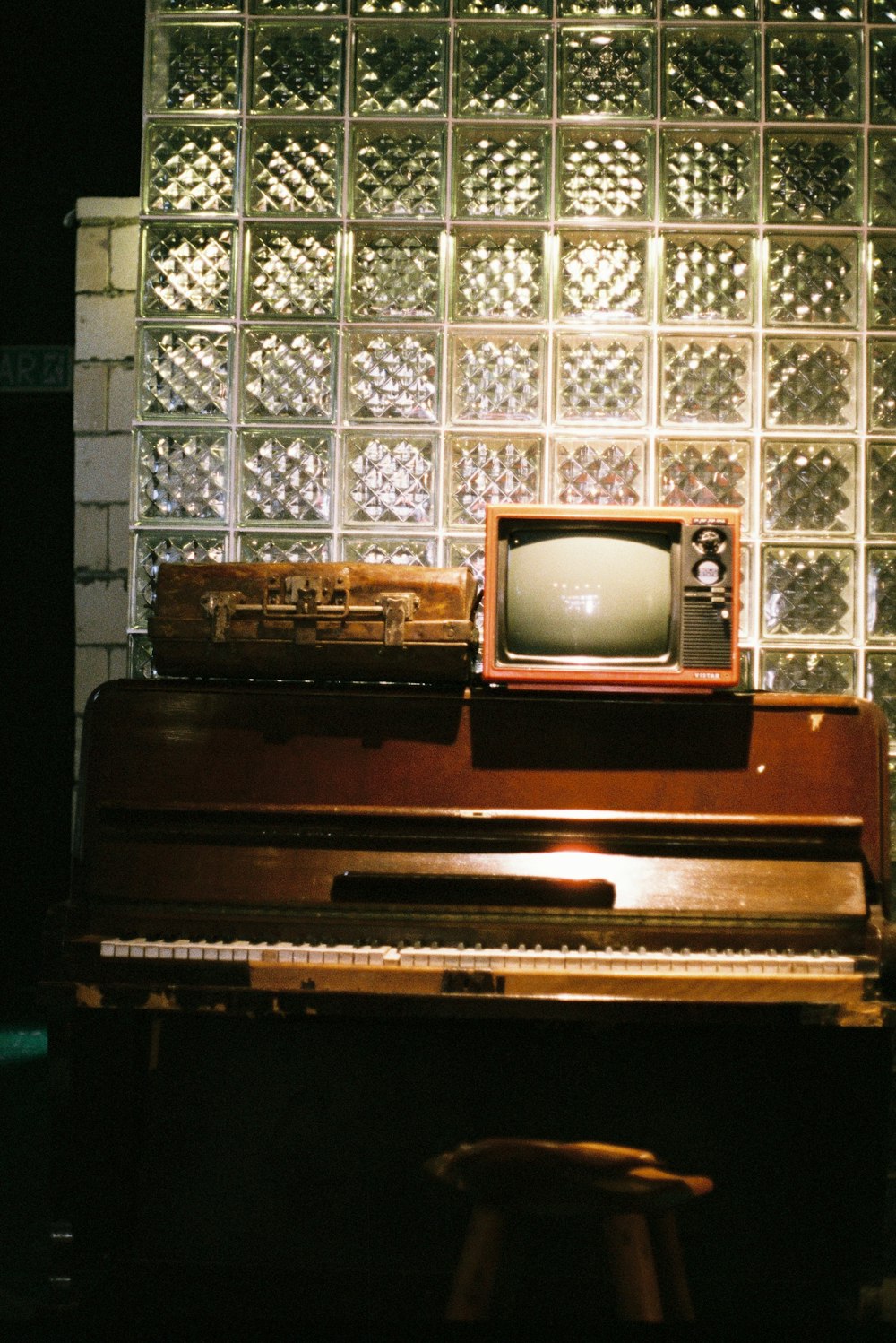 an old tv sitting on top of a piano
