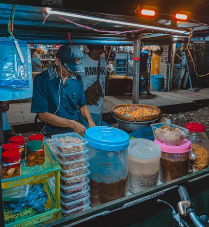 A candid moment of a street vendor preparing traditional food at a busy market.