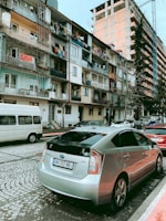 Toyota Prius + 7 seats hybrid vehicle waiting at a busy city street.