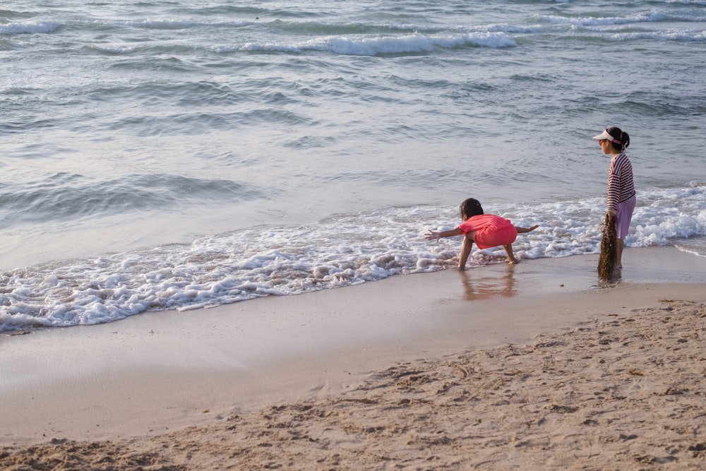 two children playing in the water at the beach