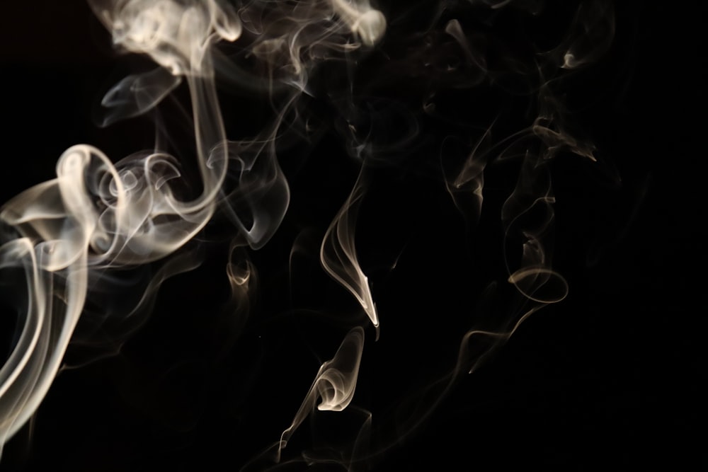 a black background with white smoke coming out of it